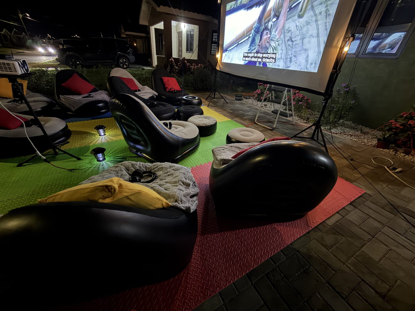 Side view of outdoor cinema at Oak Estate — screen lit with movie