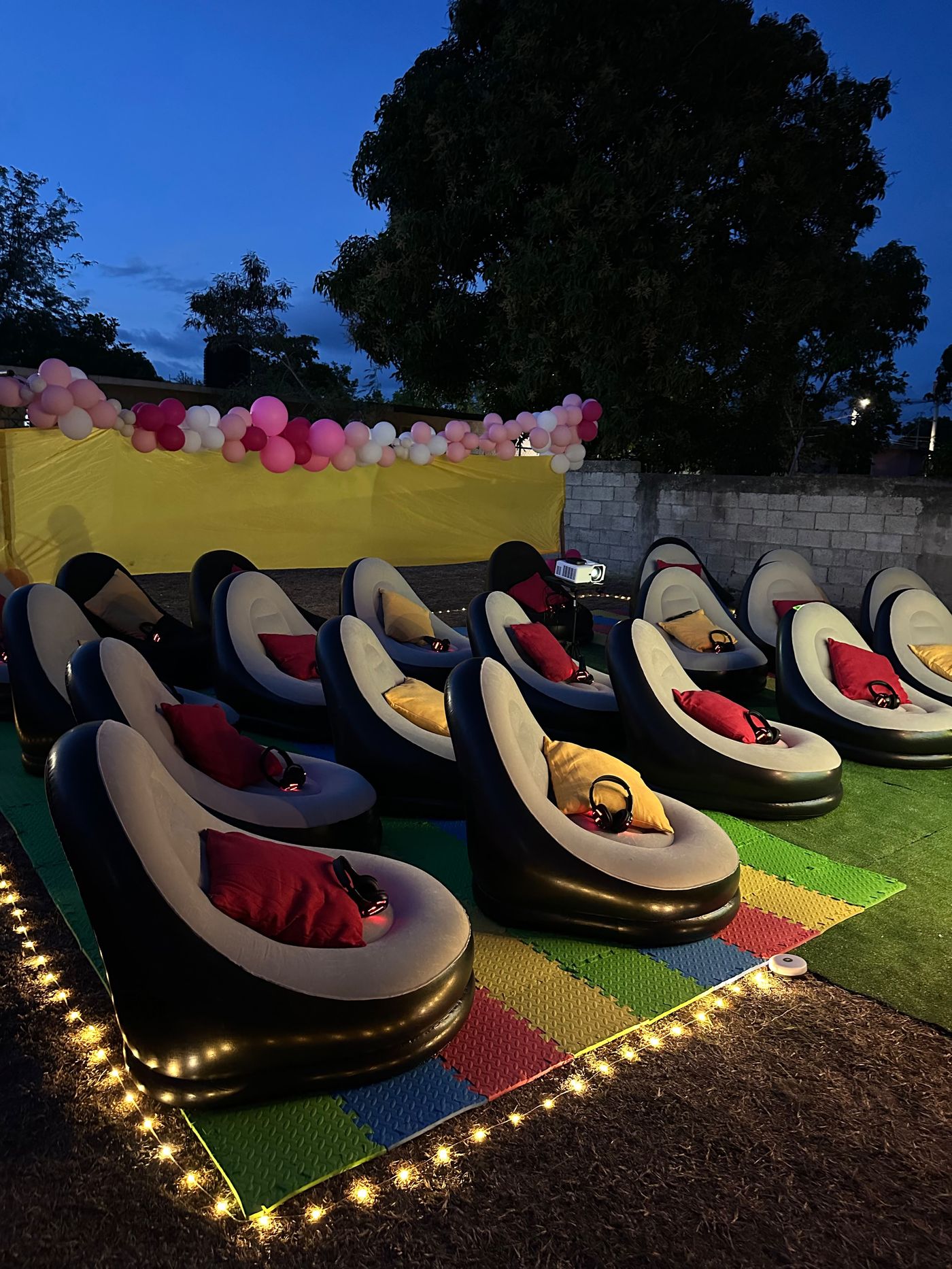 Private outdoor cinema setup in Jamaica at blue hour with inflatable seating and projection screen