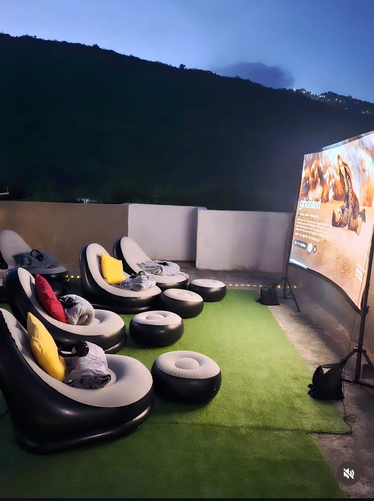 Rooftop private outdoor cinema for two in Kingston Jamaica with a projection screen and hillside view